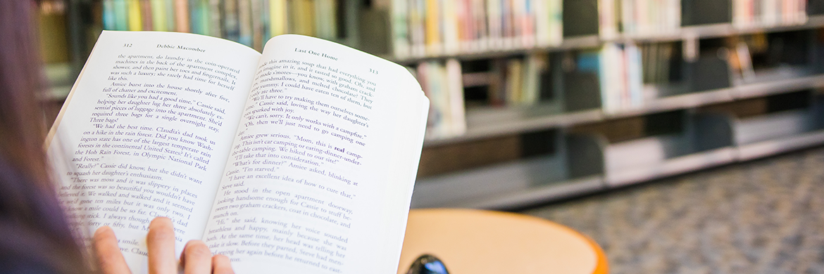 Girl reading book in library