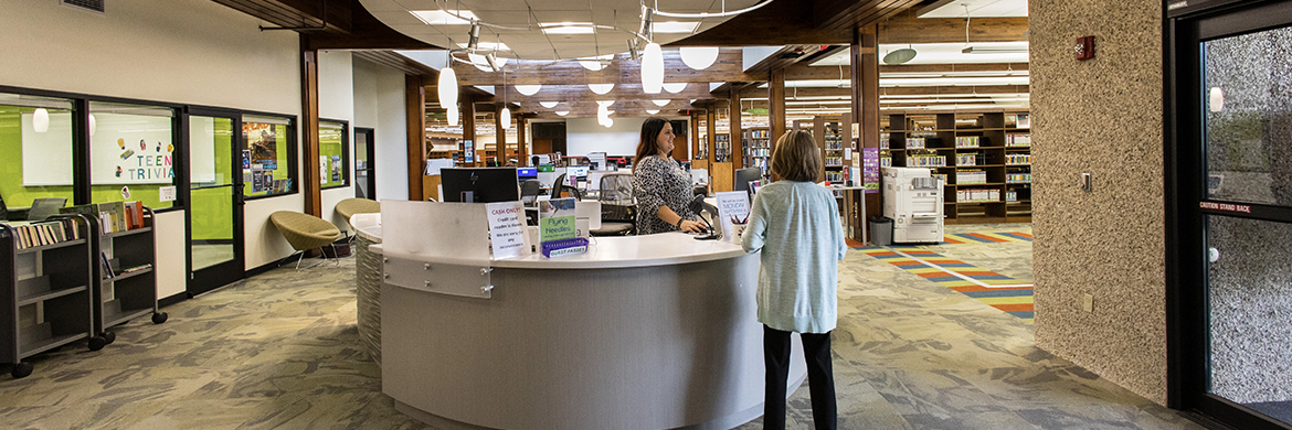 Librarian talking to patron at the circulation desk