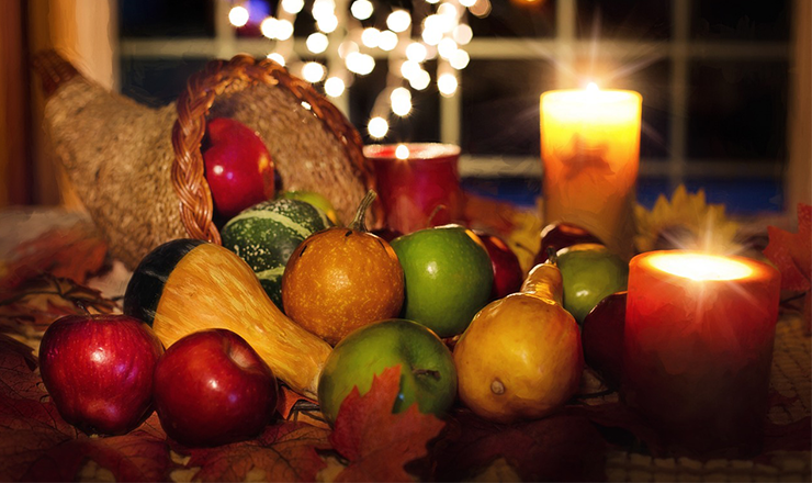 cornucopia full of fruits and vegetables by candlelight
